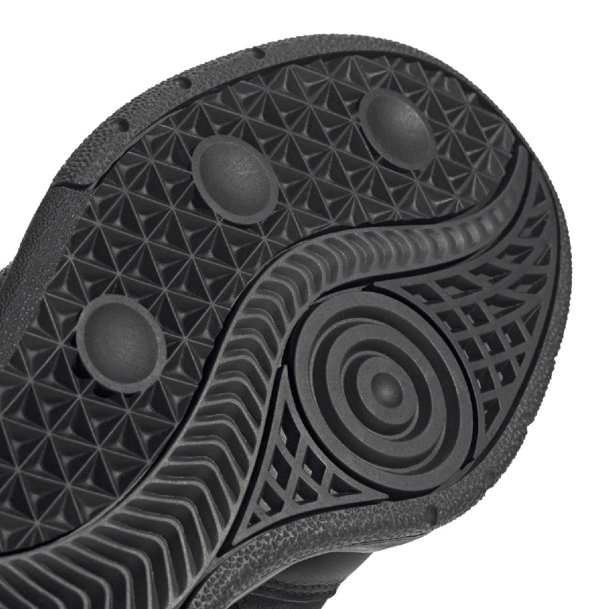 Close-up of black outsole traction with geometric tread and circular logo