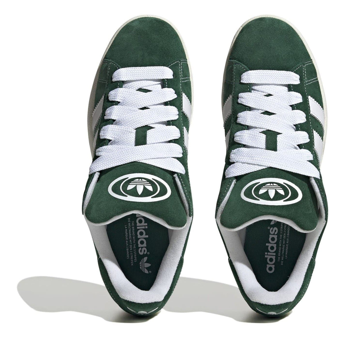 Pair of dark green low-top trainers showing adidas insole and white eyelets