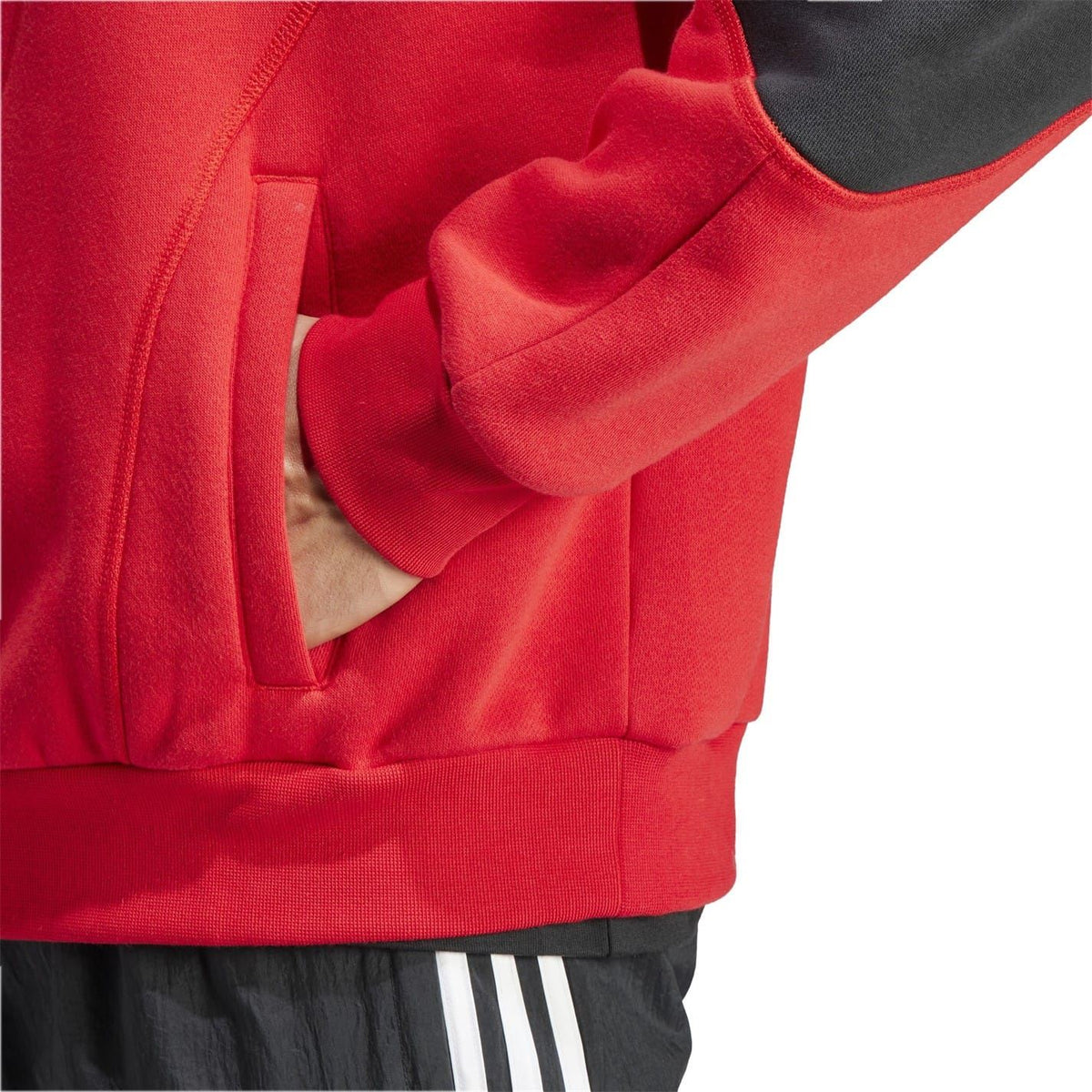 Red hoodie front close-up with kangaroo pocket, hood seam, and sleeve cuff detail.