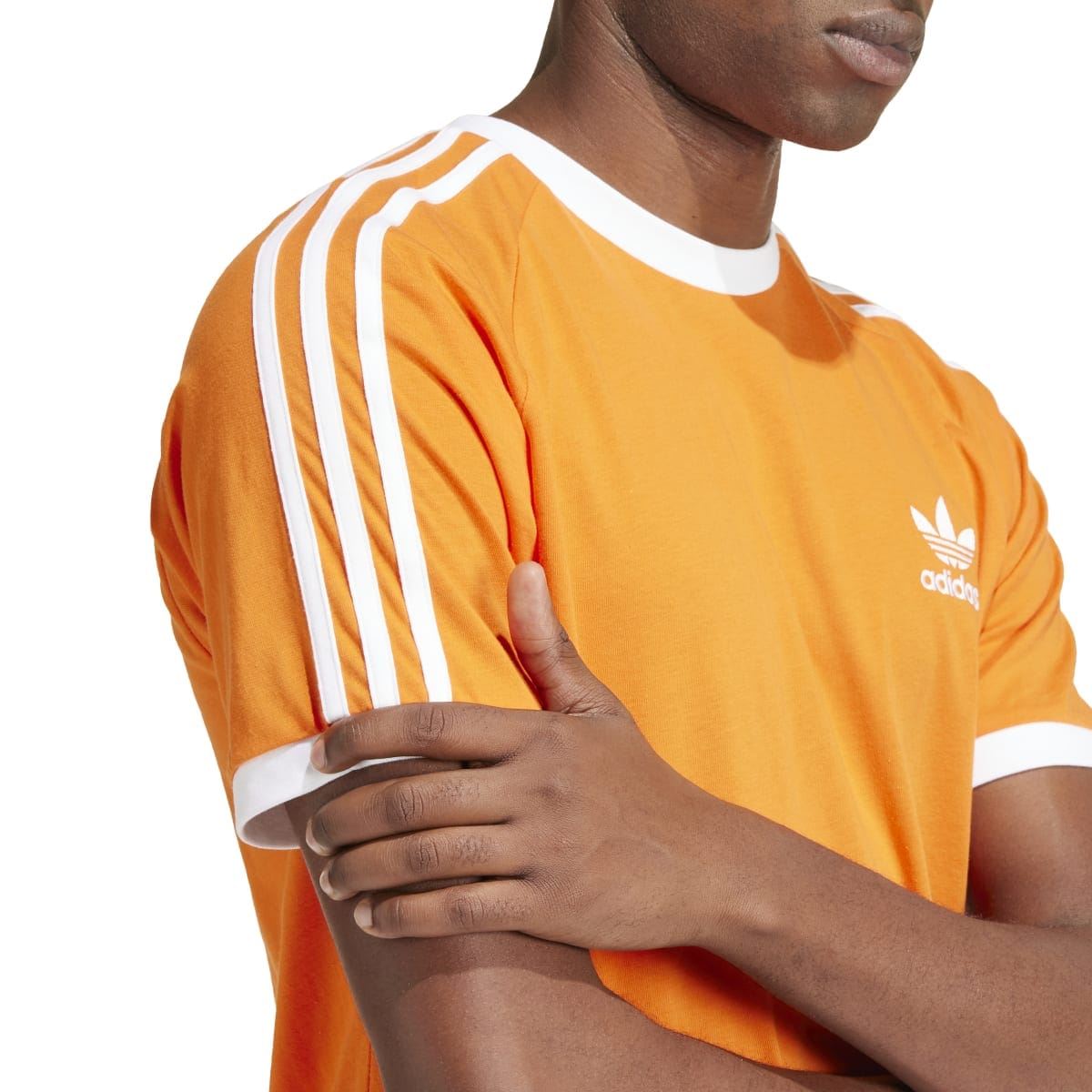 Orange adidas Originals Adicolor T-shirt close-up of white 3-stripe sleeve detail