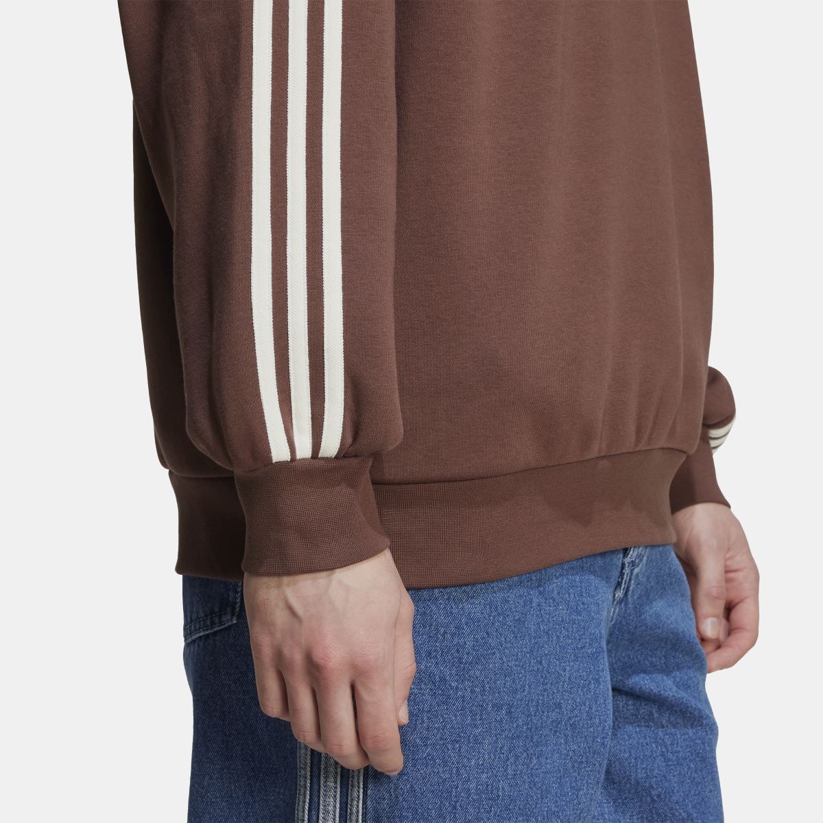 Brown sweatshirt sleeve with three white stripes, ribbed cuff, and ribbed hem