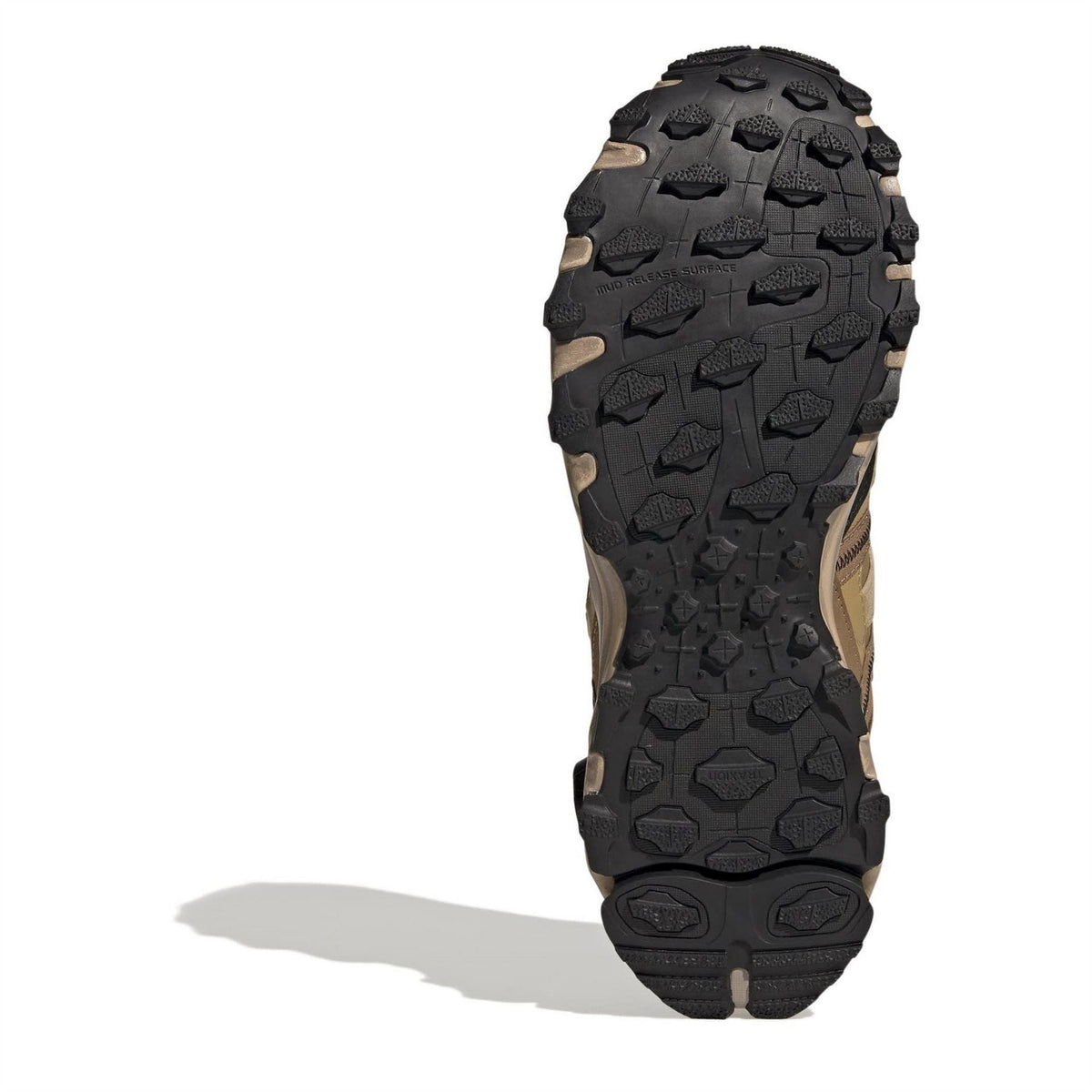 Beige sneaker outsole with dark rubber traction tread, viewed from bottom