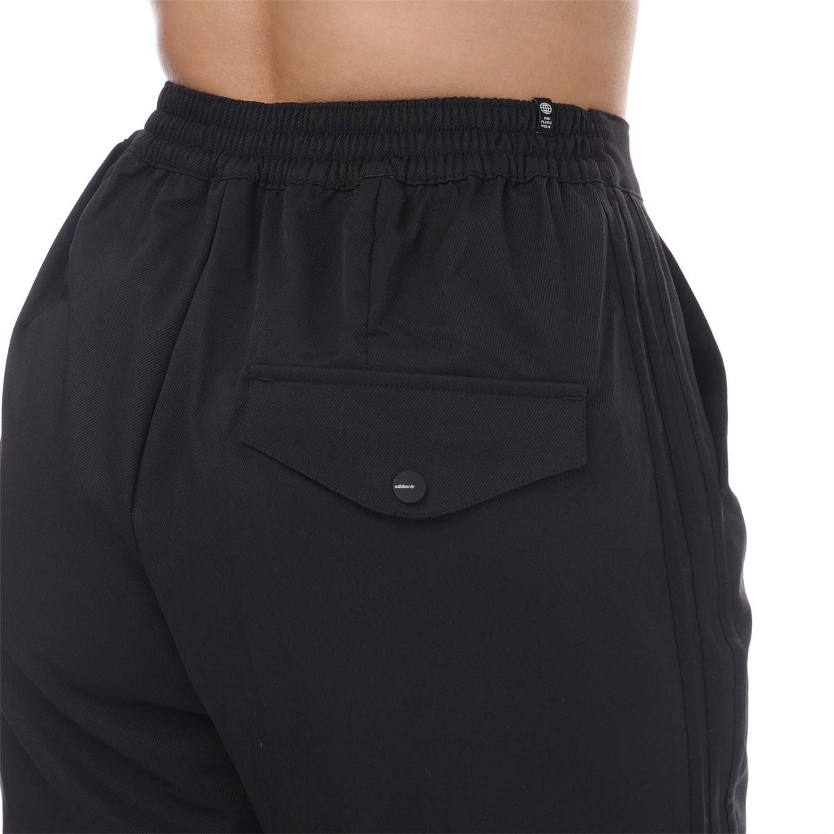 Black adidas Originals woven pants with side pocket and snap-button detail at waist