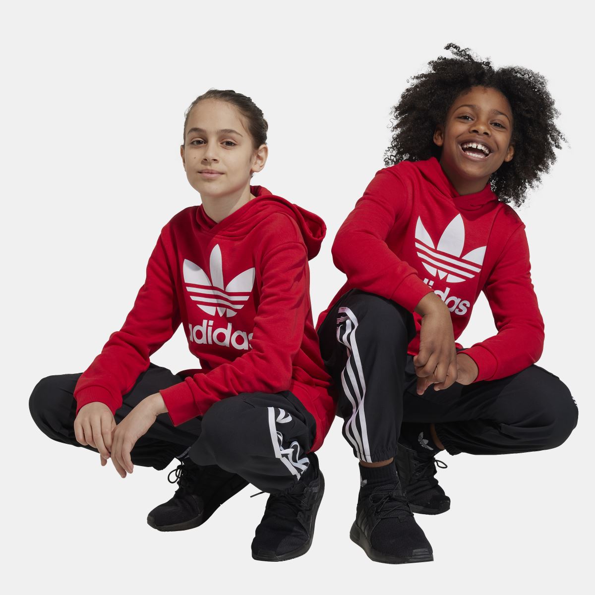 Kids black track-style cargo jogger trousers with white triple stripe side bands