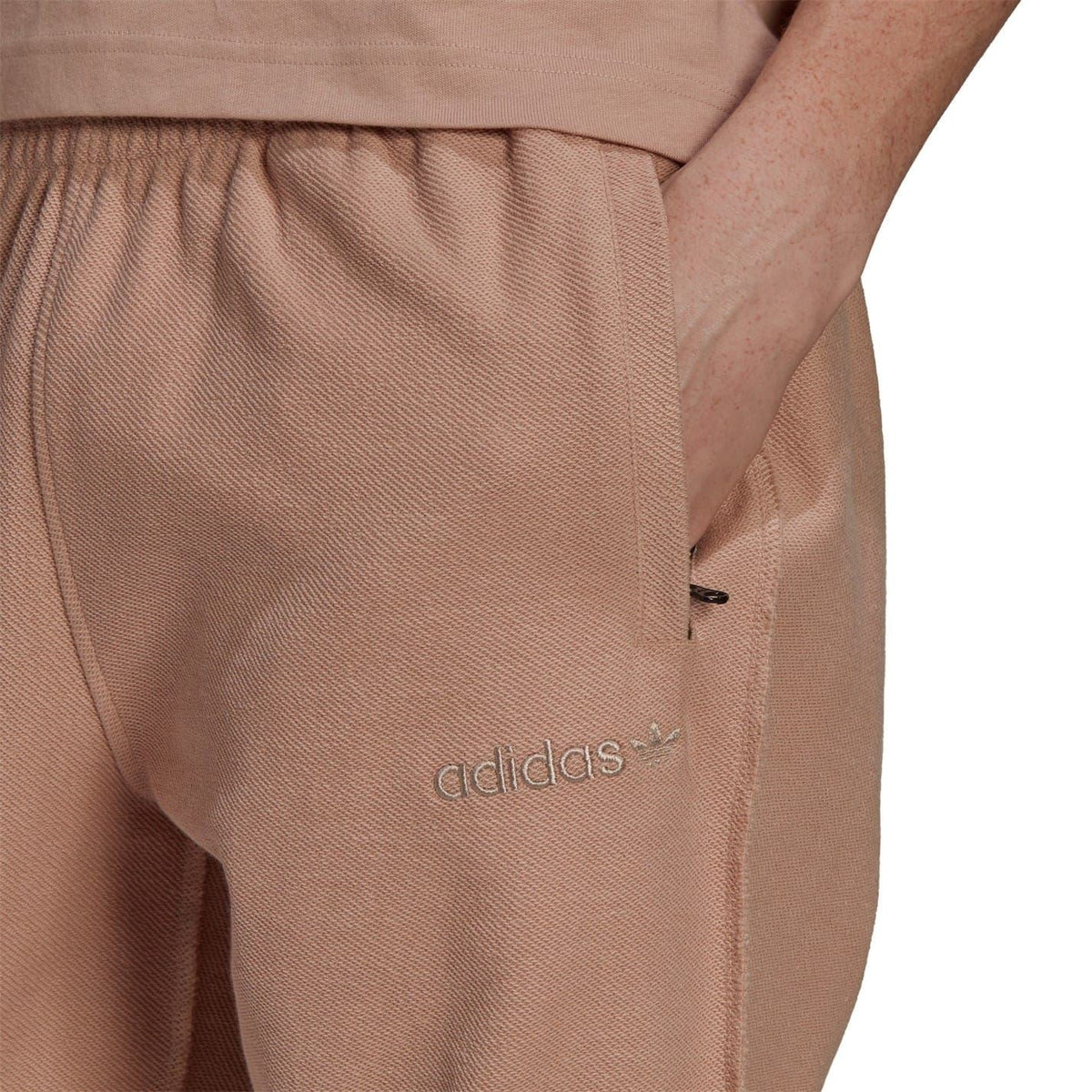Dusty pink sweatpants with adidas logo detail near the pocket