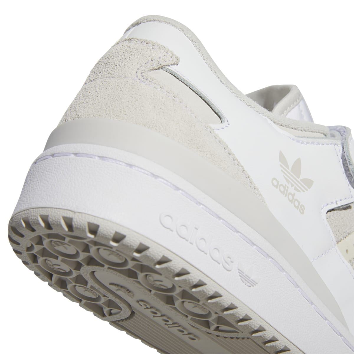 Close-up of white outsole with textured tread and 'adidas' branding at midfoot