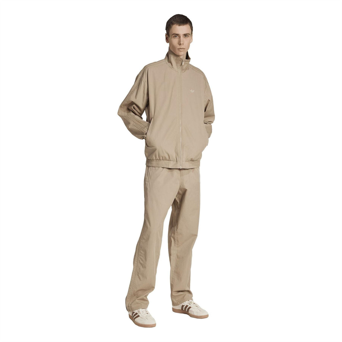 Beige track jacket on model, stand collar and full zipper with elastic cuffs