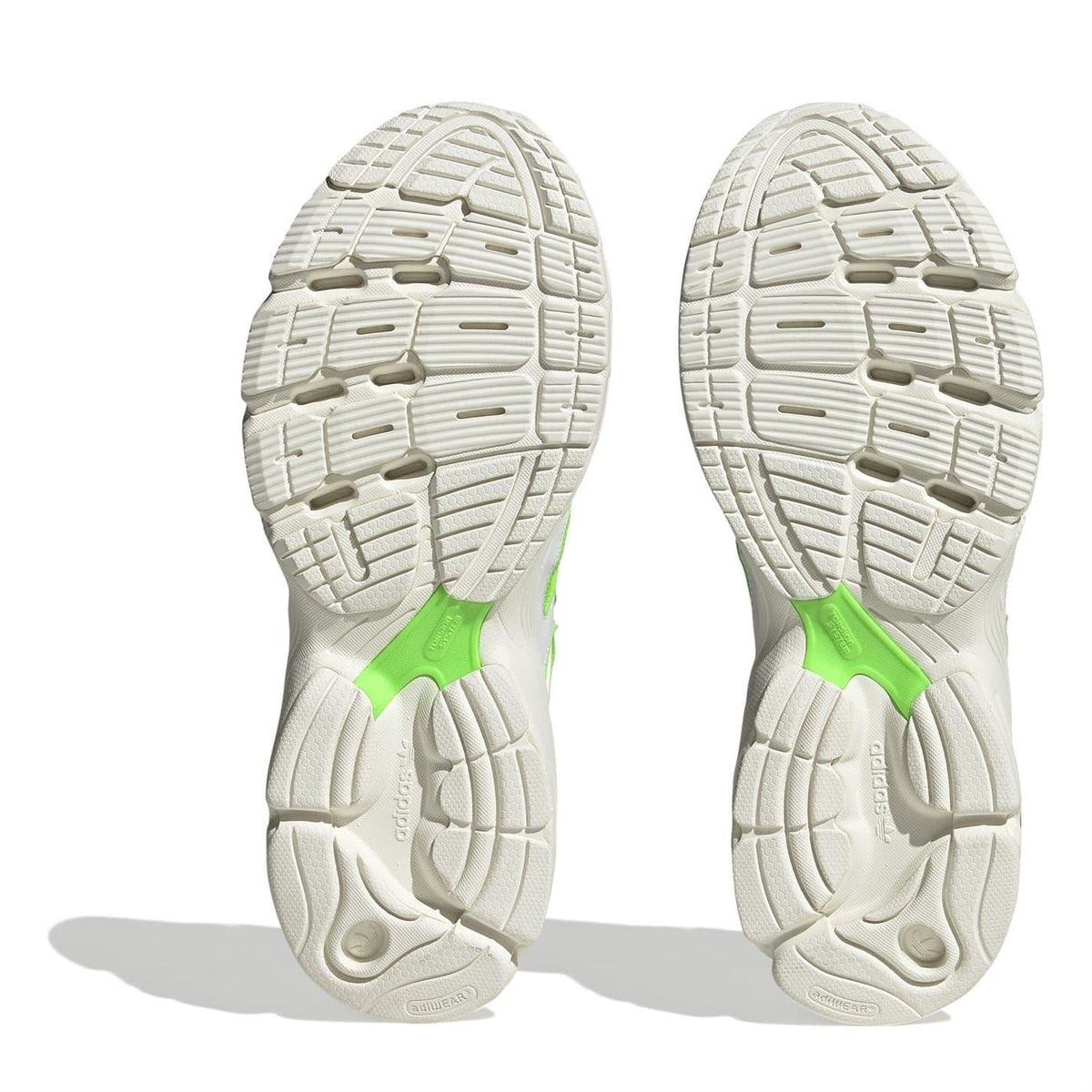 Pair of white outsoles with deep tread and neon green heel insert