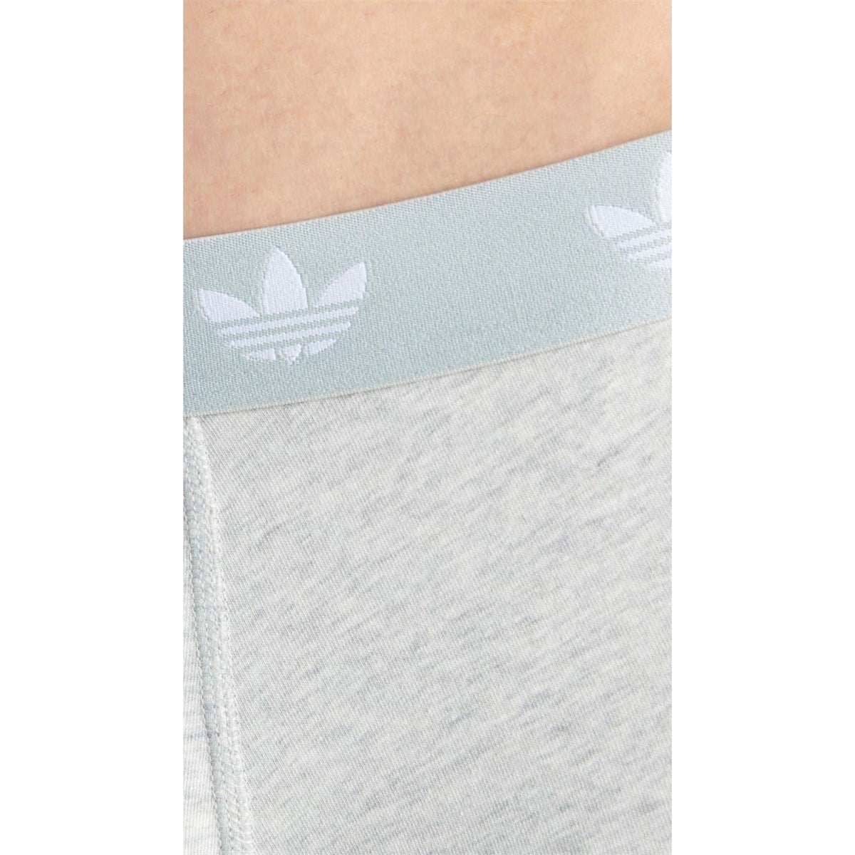 Close-up of light grey adidas logo boxer waistband with repeating trefoil pattern
