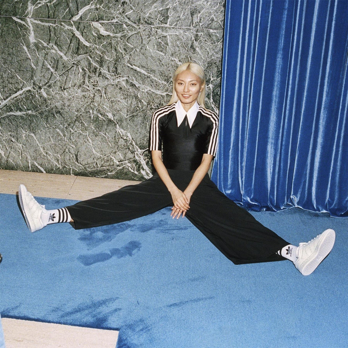 White crew socks with black adidas stripes, worn with sneakers