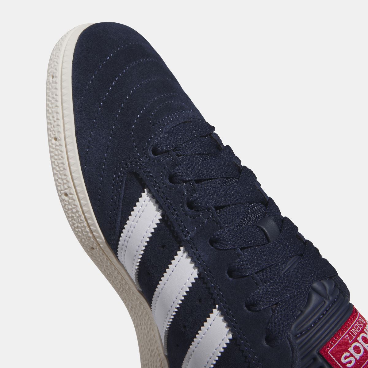 Navy Busenitz sneakers with three white stripes and red tongue label