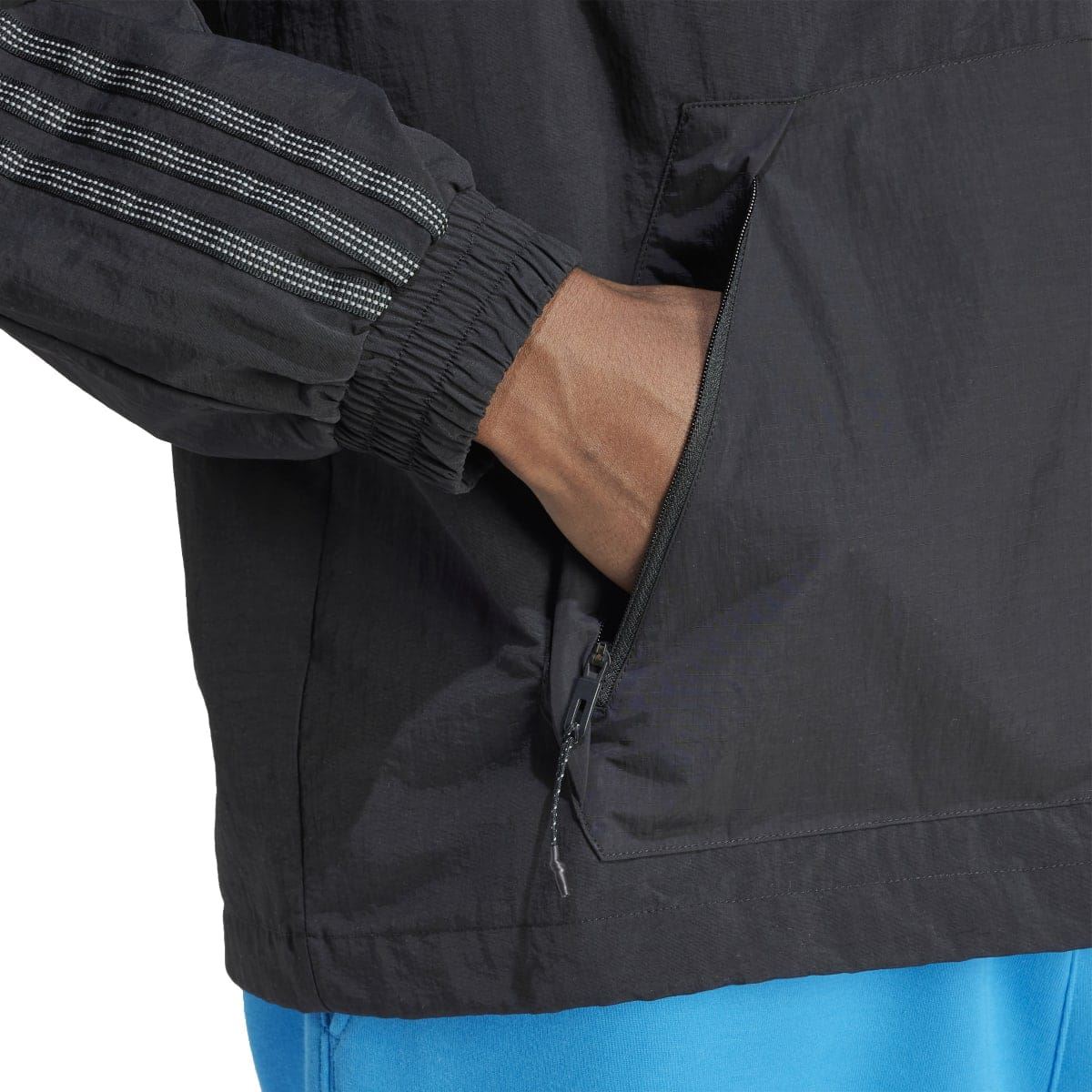 Close-up of black anorak jacket front pocket and sleeve cuff with elastic trim
