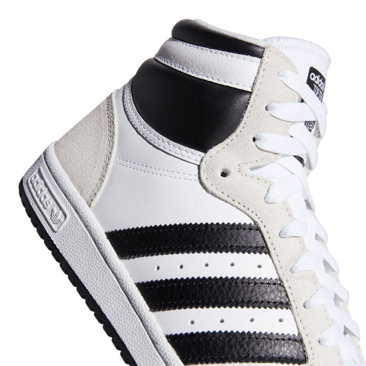 Close-up of white high-top Adidas sneaker with black stripes and textured side panel