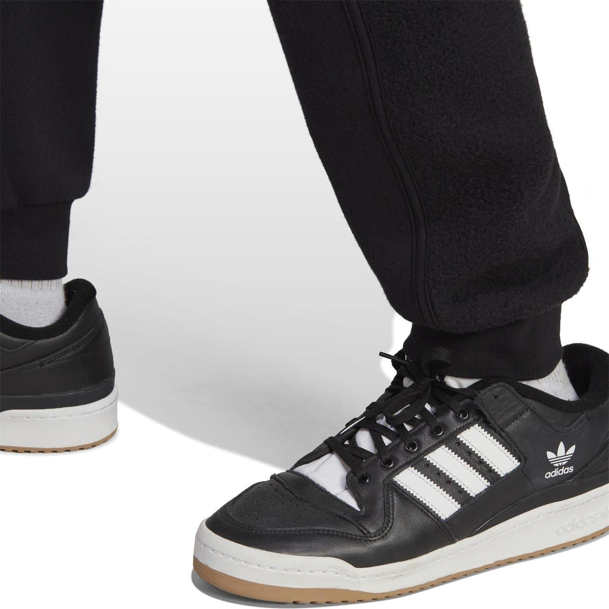 Black joggers and sneakers detail with elastic cuff and adidas branding