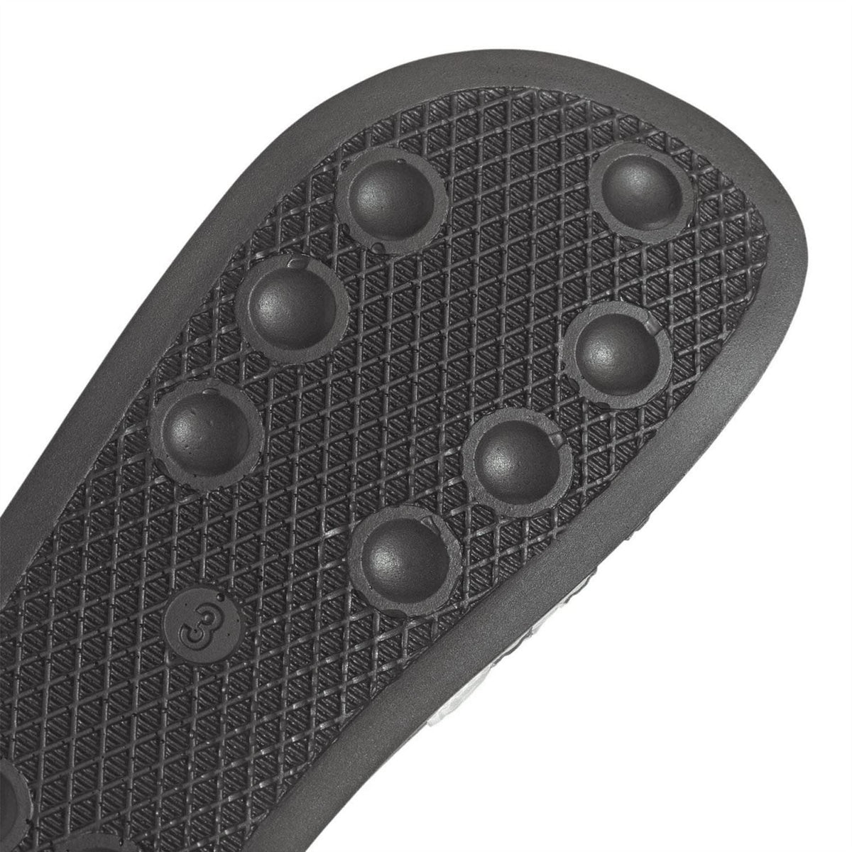 Junior slide sandal outsole with textured traction nubs