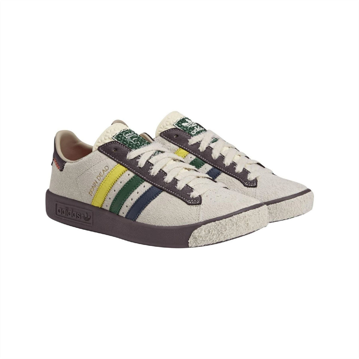 Cream low-top sneakers with navy stripes, green/yellow center stripe and brown sole