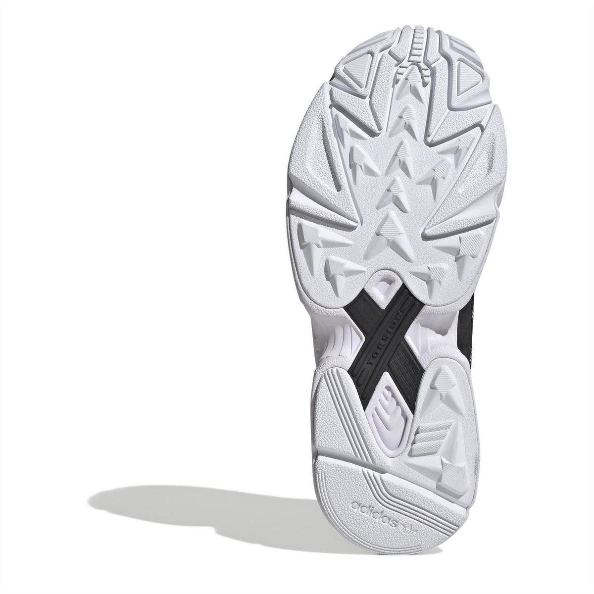 Black outsole tread on the underside of a black-and-white low-top lace-up sneaker