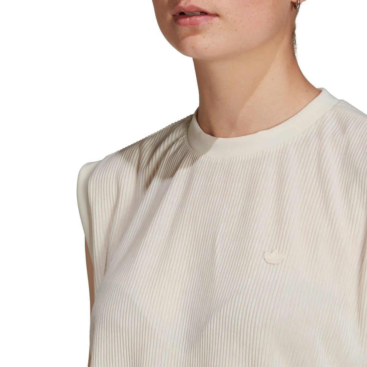 Cream ribbed crew-neck tank top close-up with small chest logo