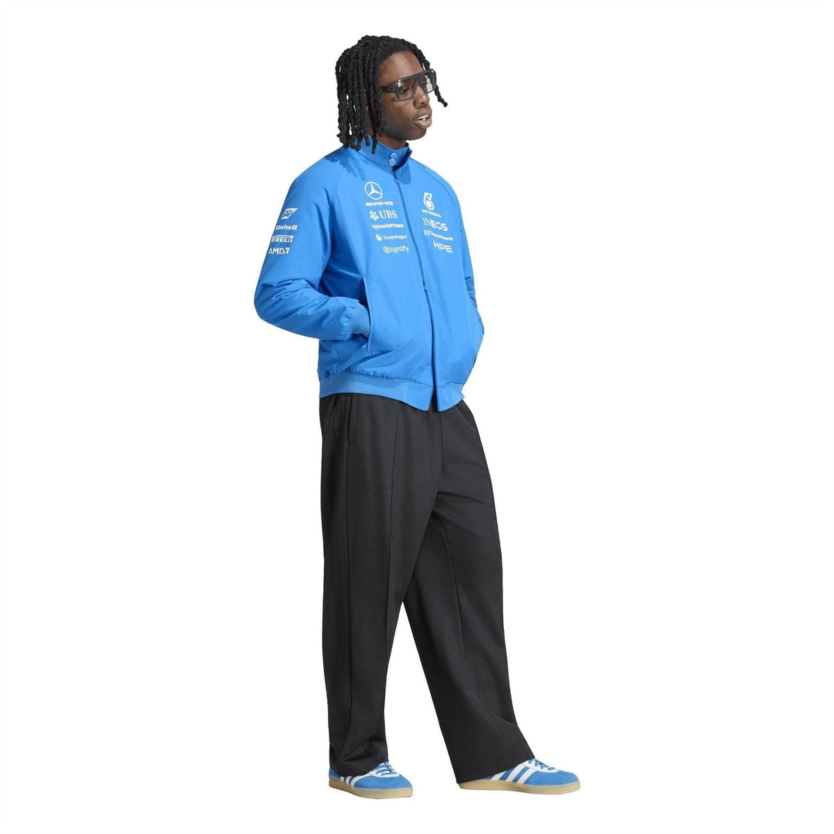 Blue zip-up Harrington jacket worn with black pants; stand collar and sleeve logos.