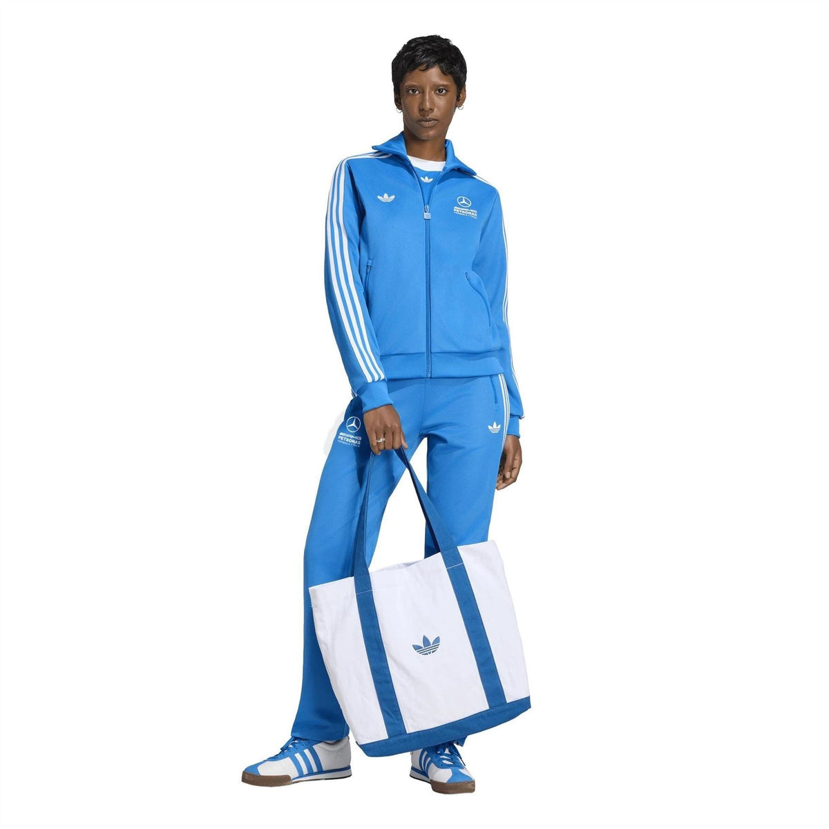 Blue track top with white sleeve stripes and full zip, worn with matching track pants.