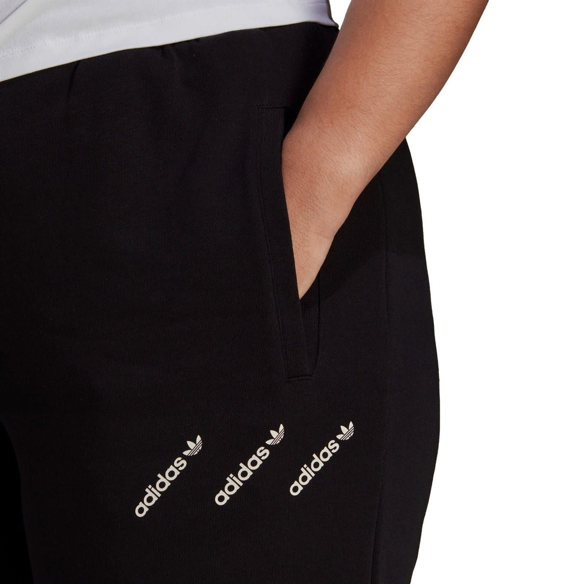 Black sweatpants close-up featuring adidas Originals logo near the side