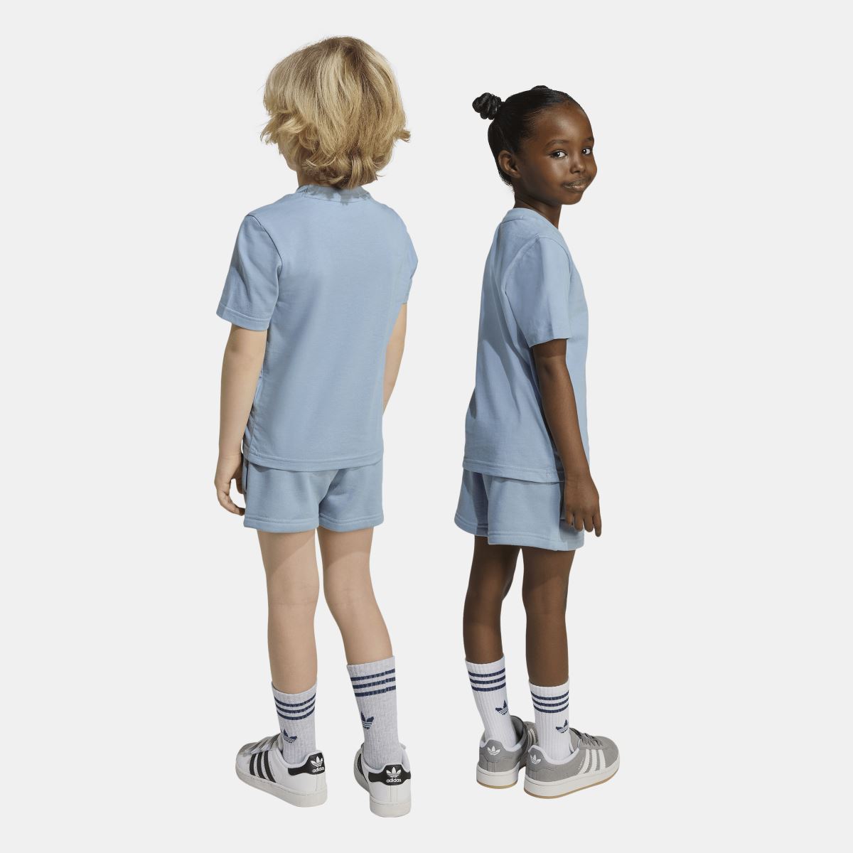 Light blue adidas kids T-shirt and shorts set, rear view on two models.