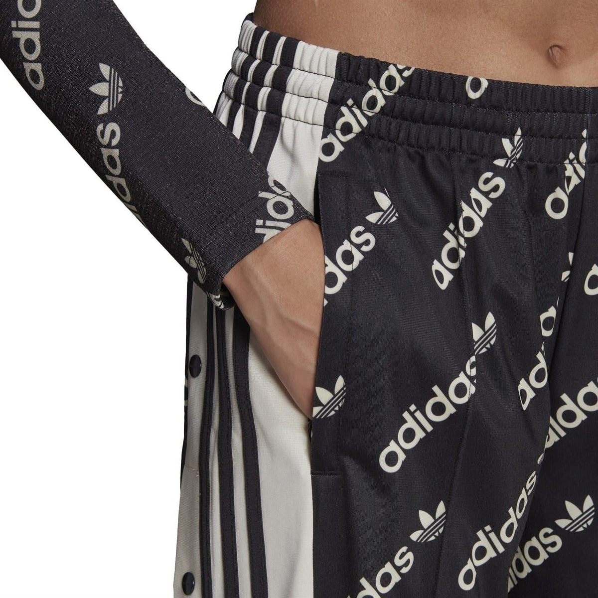 Black jogger sweatpants close-up: elastic waistband, adidas logo print, side stripe seam