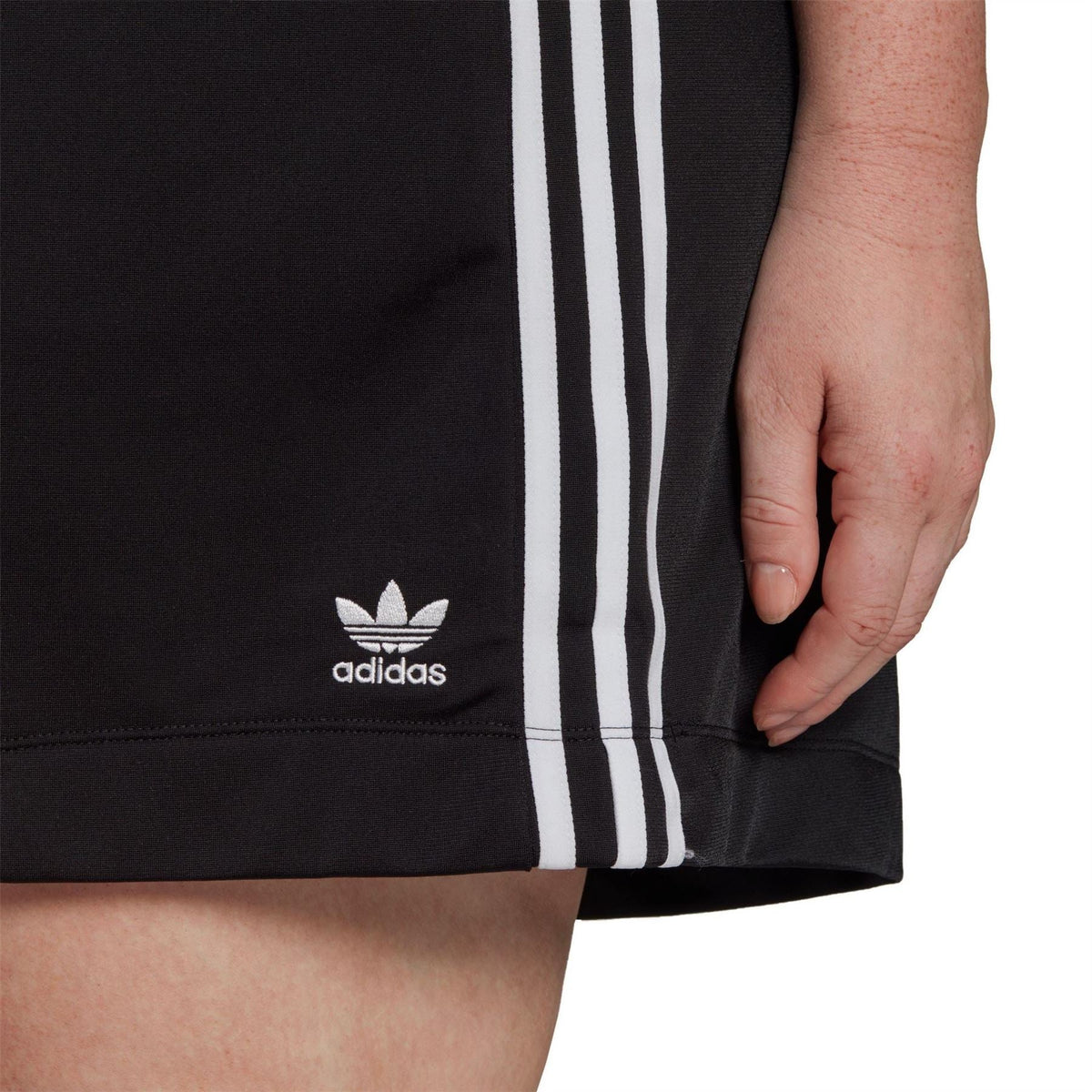 Black skirt hem with adidas logo and vertical white triple stripes
