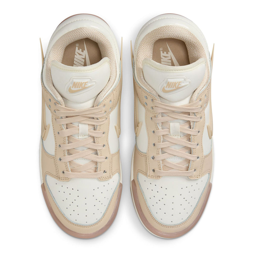 Lace-up sneakers top view with beige laces, Nike tongue label, and sail toe panels