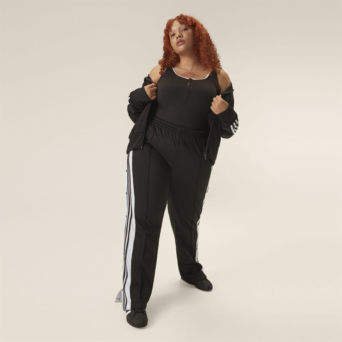 Black track-style running pants, side stripe, elastic waist, drawcord detail, ankle cuffs