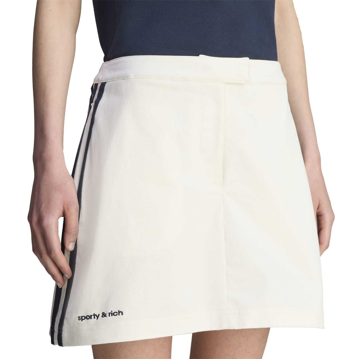 Core White Sporty & Rich skirt close-up, navy side stripes on waistband