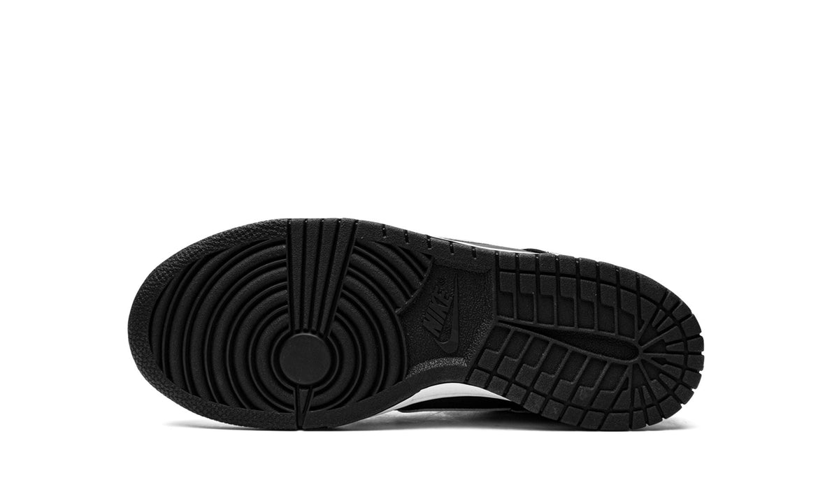 Black rubber outsole of low-top kids' Nike sneakers with traction tread