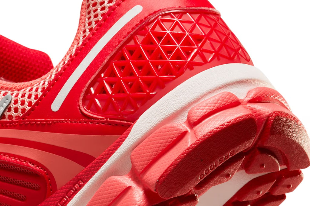 Red textured outsole and mesh upper on running sneaker, close-up