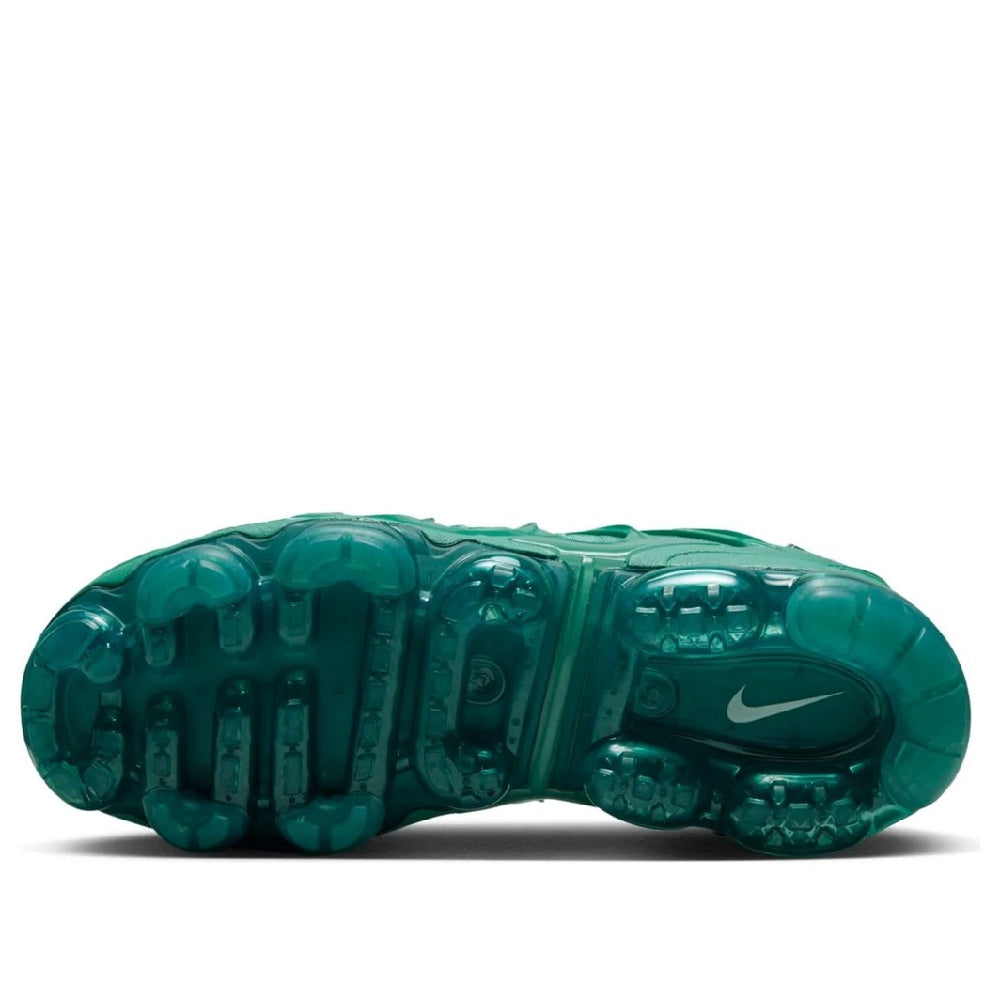 Green Nike Air Vapormax Plus shoe outsole view with grippy traction pods and teal Max Air units