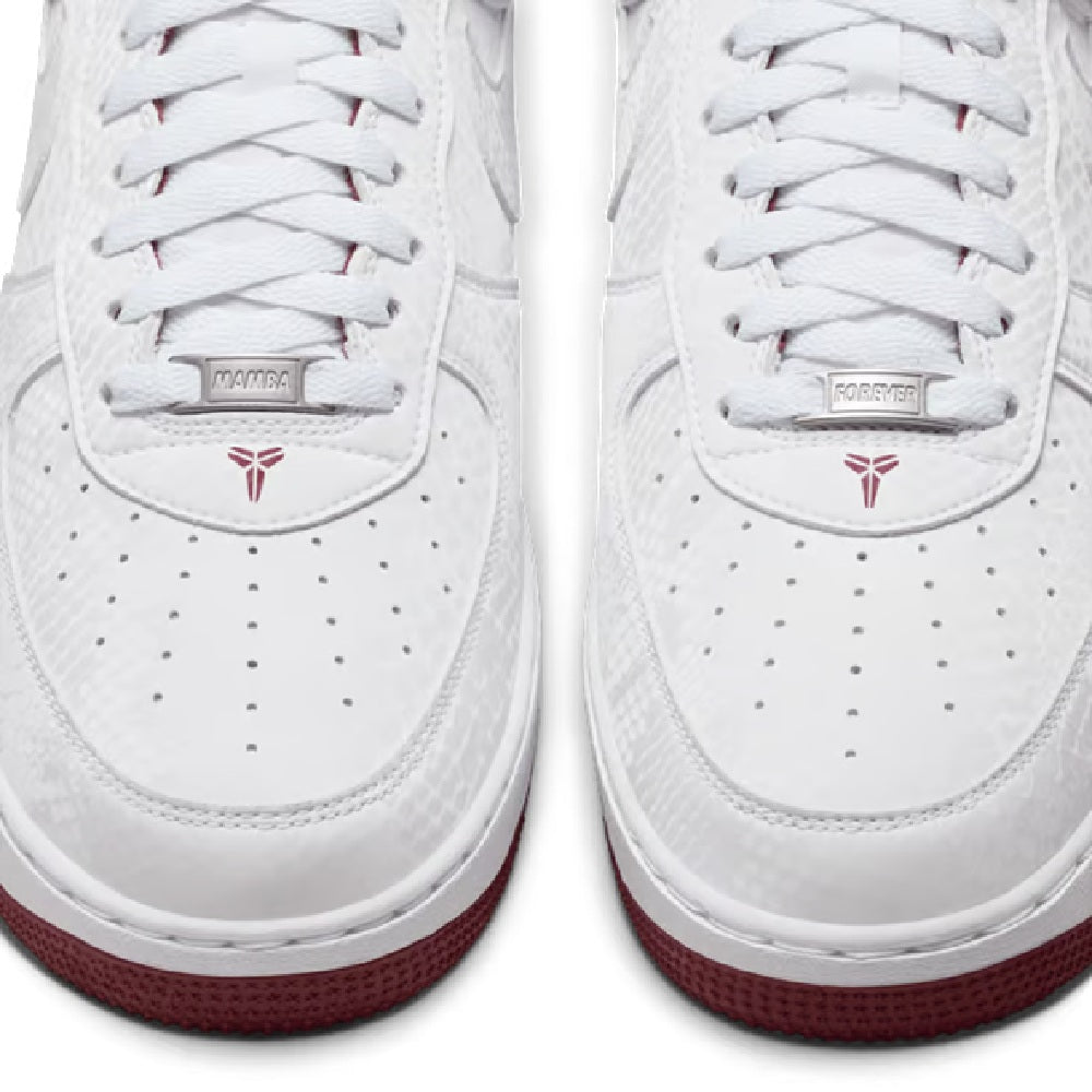 Close-up of Nike Kobe white sneakers: lace-up panel with printed label and red spade logo