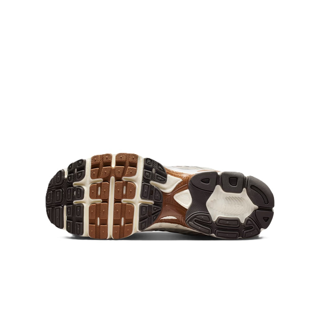 Men's Nike Air Max sneakers outsole view, brown-and-black tread with cream upper