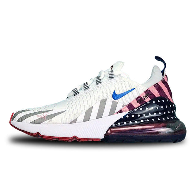 White running shoes with blue swoosh, gray side stripes, pink/navy panel, lace-up