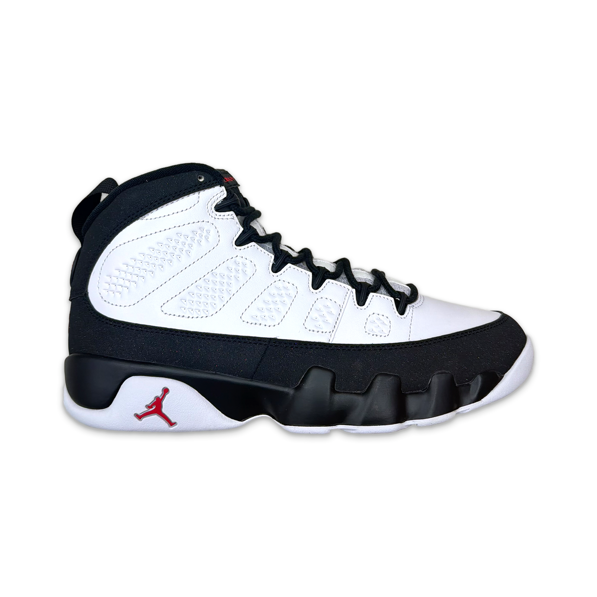 Air Jordan 9 Retro mid-top basketball shoe, white leather with dark navy accents, lace-up.
