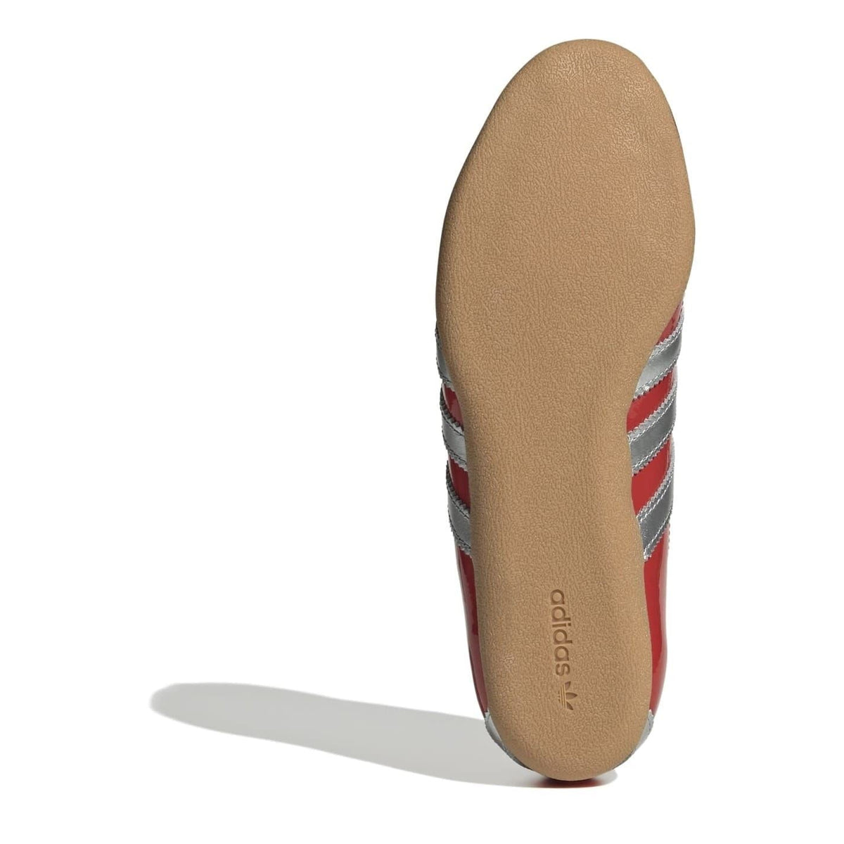 Shoe outsole view of red low-top sneakers with adidas branding on the insole