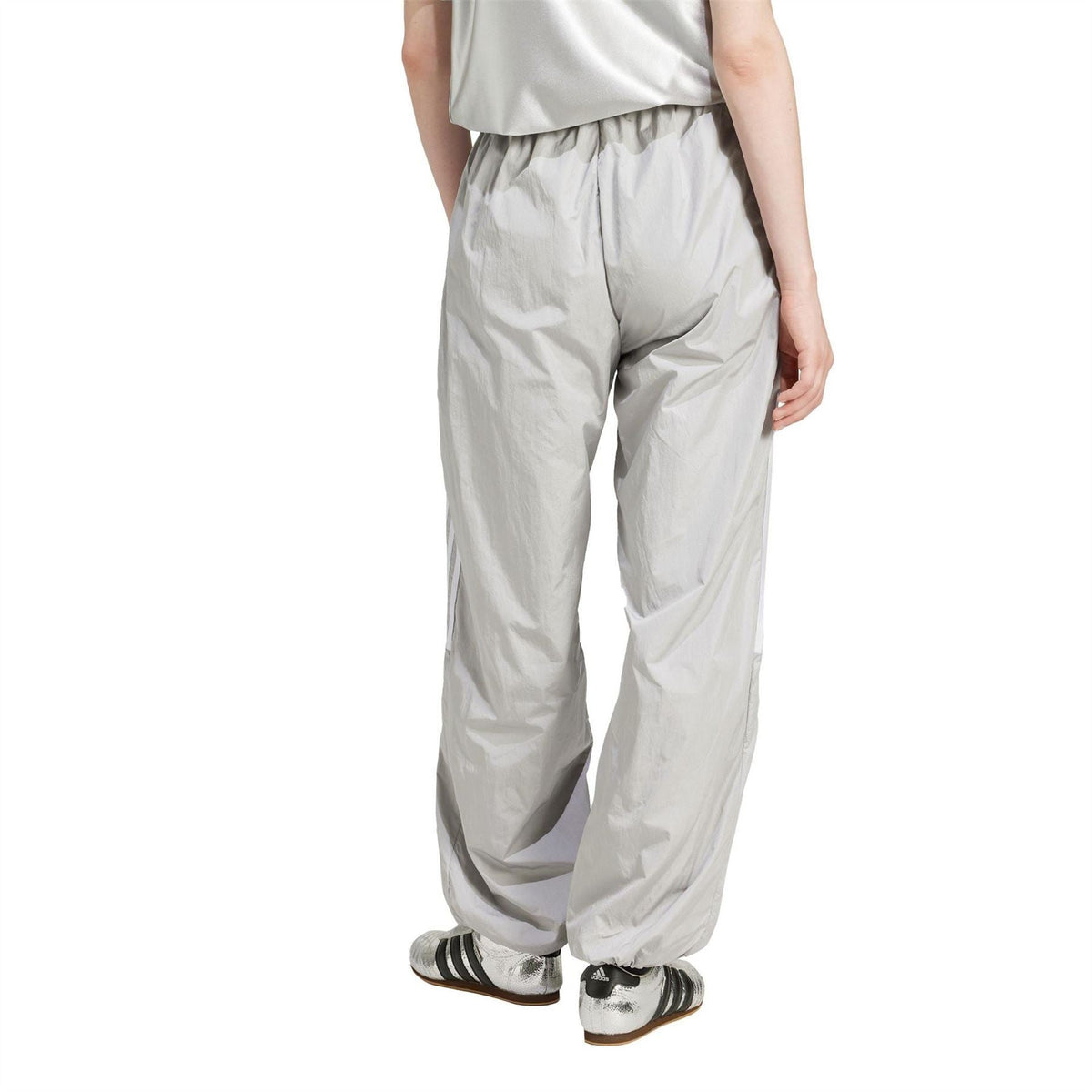 Light grey track pants side view with relaxed fit and elastic waistband