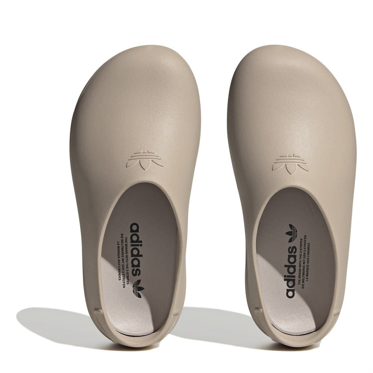 Beige low-top trainers viewed from toe, showing adidas branding on footbed