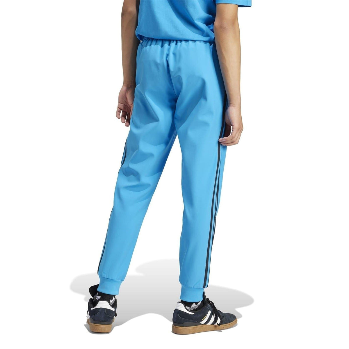 Blue track pants with slim leg, side stripe panels, and elastic cuff hems
