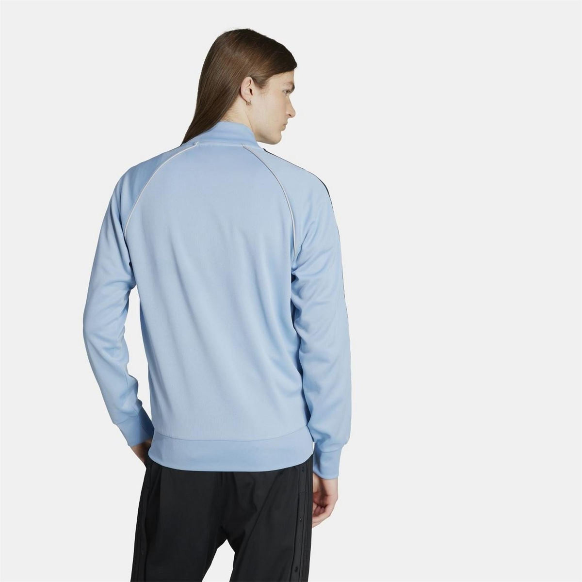 adidas Originals Classic SST Track Jacket in navy with white stripes, displayed on a hanger against a plain background
