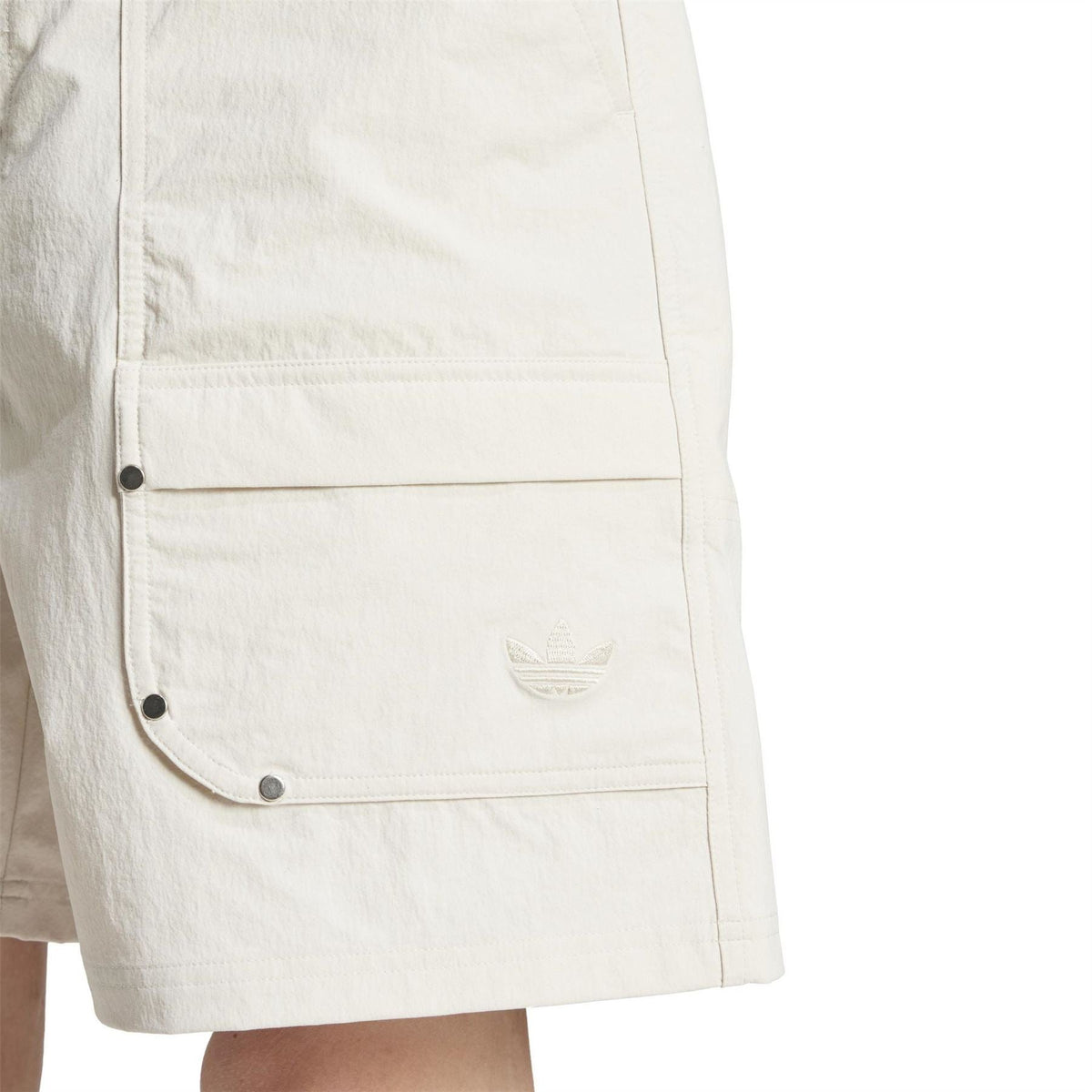 Light off-white shorts close-up of side cargo flap pocket with snap buttons