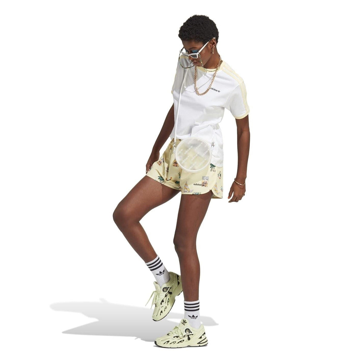 Cream athletic shorts with allover multicolor graphic print and shirred elastic waist