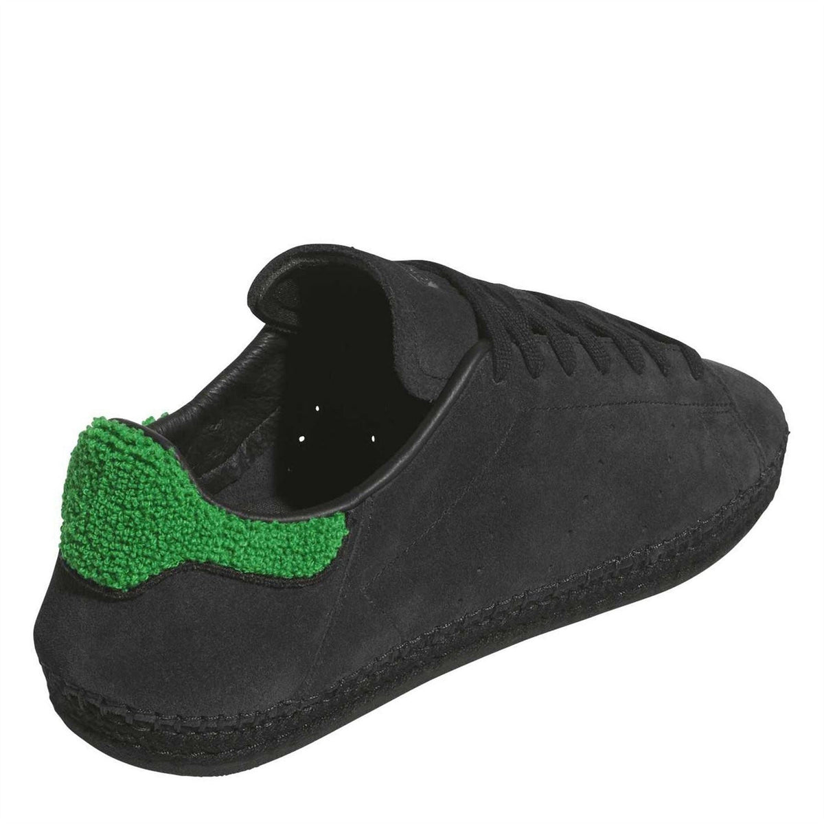 Black suede trainers with green heel panel and visible interior lining