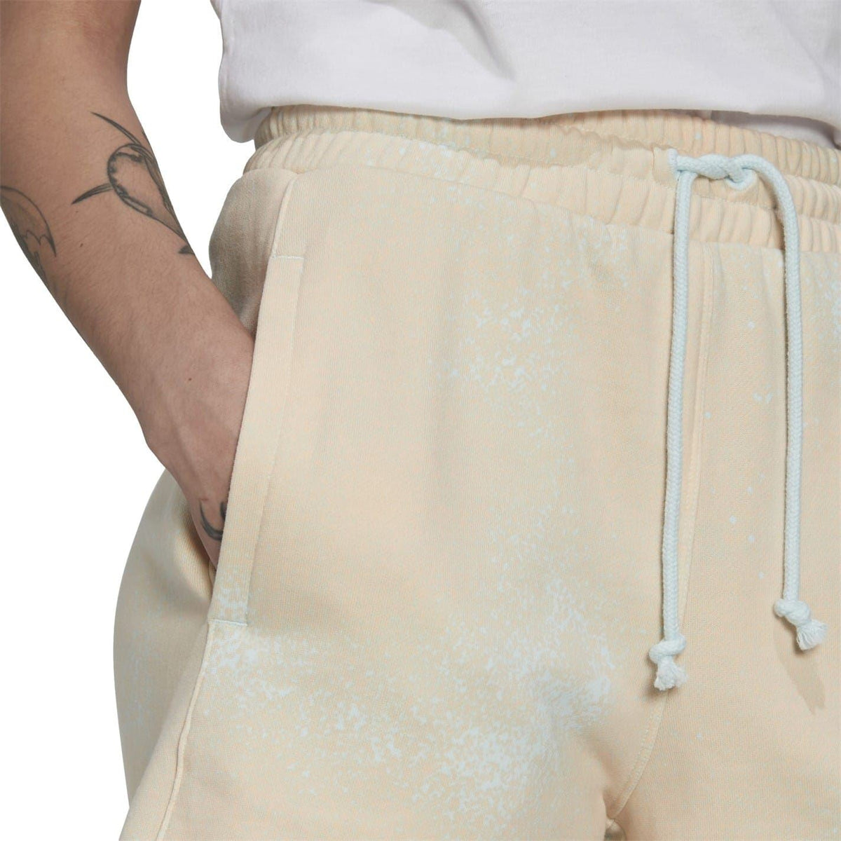 Cream drawstring waist sweat shorts with elastic waistband and hanging cords