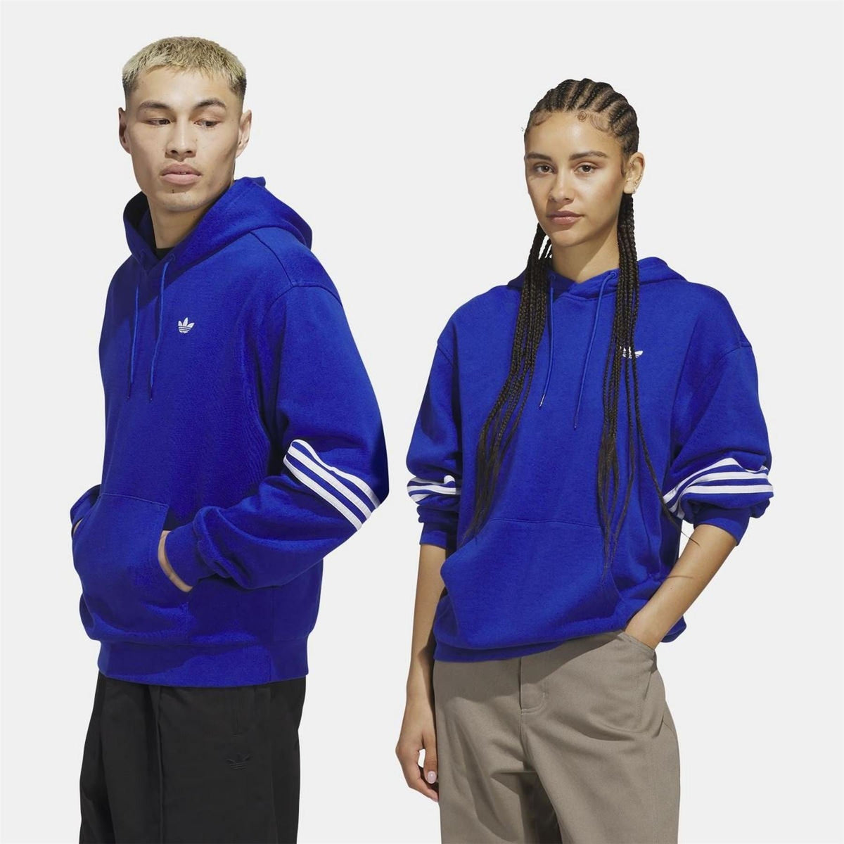 adidas Originals blue hoodie on model, front trefoil logo with striped sleeves