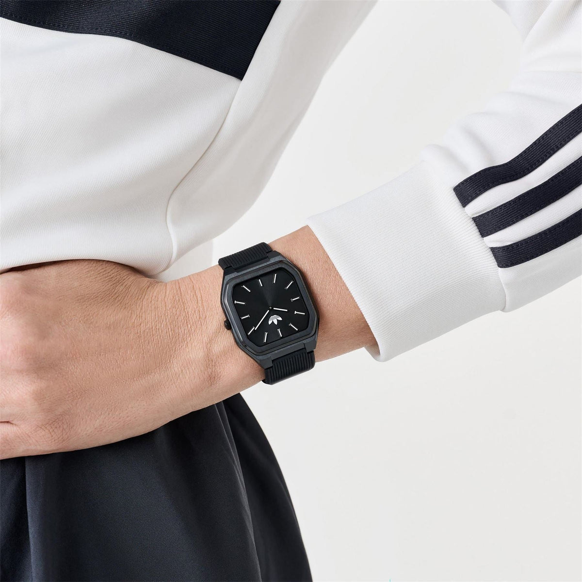 adidas Originals watch on wrist, dark dial with black case and black ribbed silicone strap