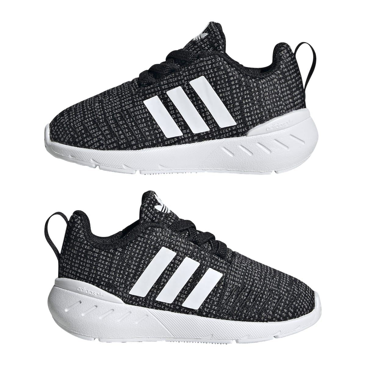 Pair of infant black knit trainers with white stripes, lace-up design, and white soles